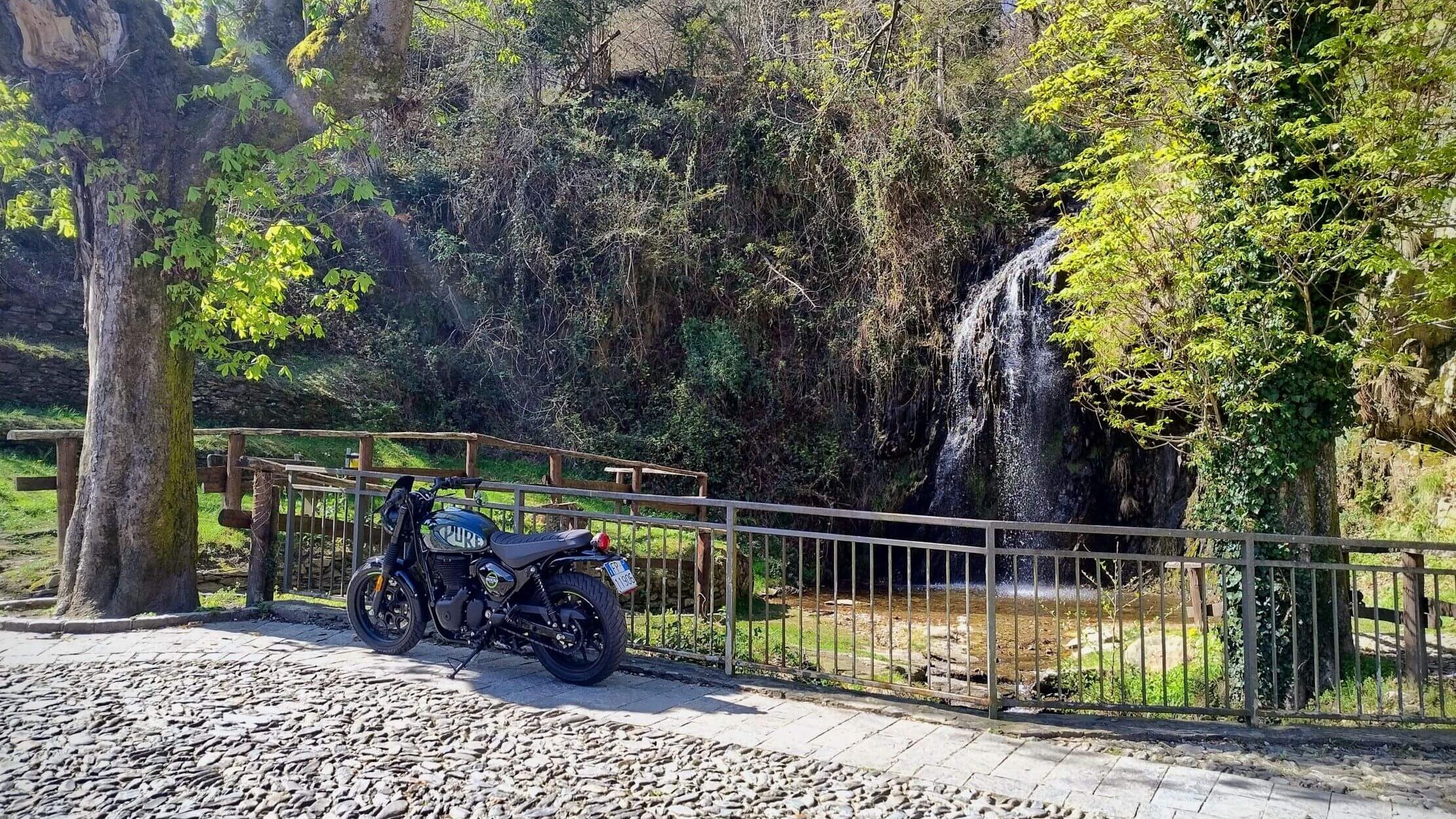 Cascata di Roggiano in un parco di paese, con Royal Enfield in primo piano per anello in moto